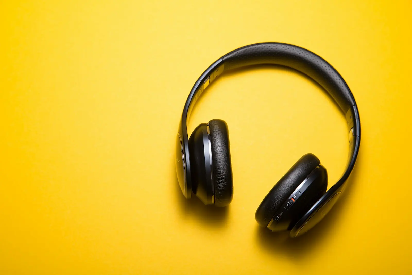 Headphones photographed on a plain coloured background