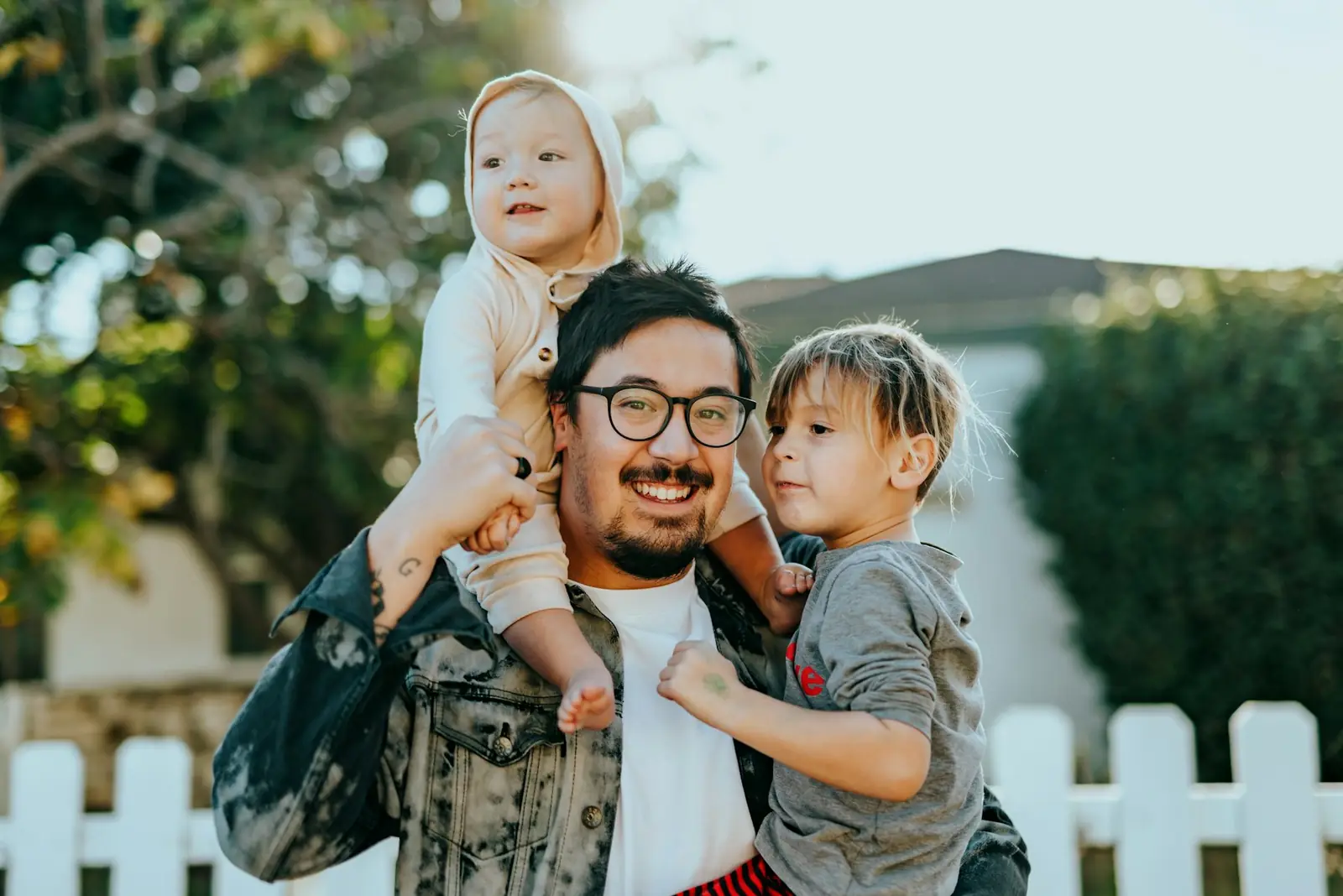 A family grouped closely and smiling outdoors