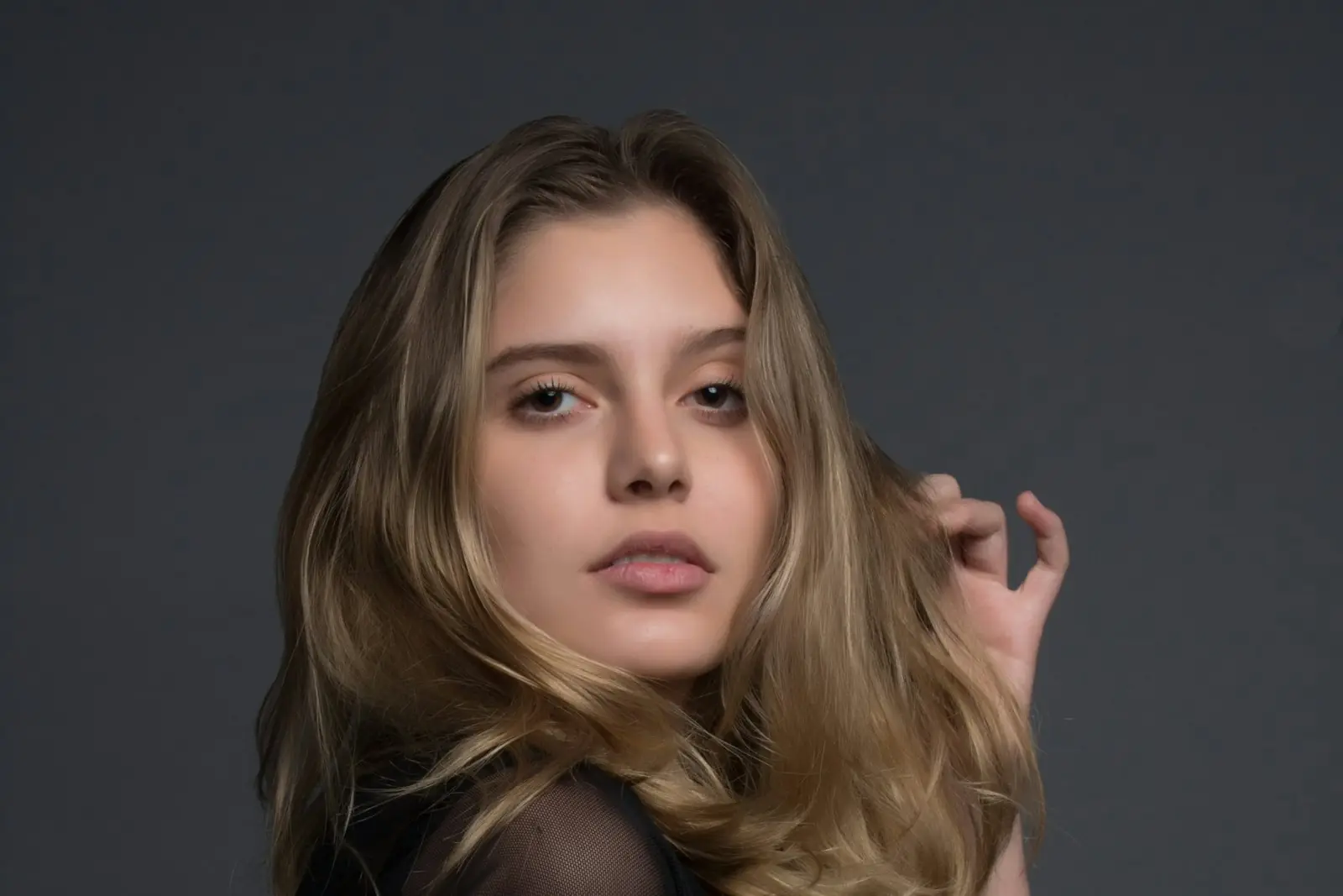A studio portrait with the whole face and shoulders